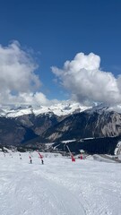 Fototapete - View of Courchevel ski resort with skiers on the slopes
