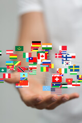 Leinwandbilder - Image of a hand holding a network of world flags, symbolizing global connections and international cooperation.