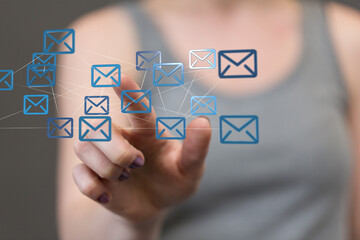 Hand pointing at a network of email icons,digital communication concept.