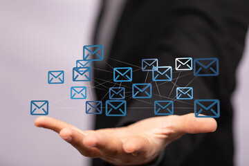 Fototapete - Hand holding digital email icons, representing global communication and networking.