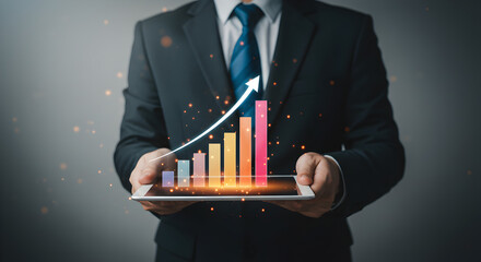 Poster - Man in Black Suit Holding Tablet Displaying Rising Bar Graph Against a Dark Gray Backdrop