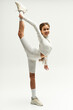 © LIGHTFIELD STUDIOS - Stylish teenager practicing dynamic flexibility in modern studio setting