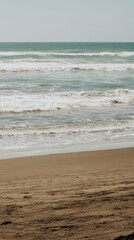 Wall Mural - Scenic View of Ocean Waves Gently Crashing on a Tranquil Sandy Beach with Clear Skies and Serene Atmosphere Ideal for Relaxation and Nature Lovers