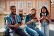 © Drazen - Multiracial group of college students using their smart phones at campus.