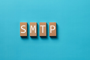 Poster - There is wood block with the word SMTP. It is an abbreviation for Simple Mail Transfer Protocol as eye-catching image.
