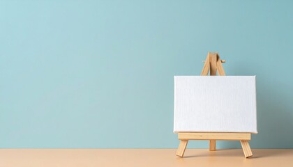 Poster - Empty canvas on easel against blue wall.