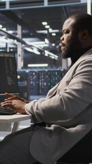 Poster - vertical video exhausted server farm employee stretching back after sitting too long at computer des