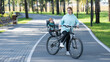 © Михаил Решетников - Caucasian woman riding a bicycle with her toddler son sitting behind her in a child seat.