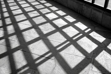 Aufkleber - Geometric shadows cast a pattern on a stone floor surface