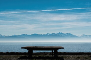 Aufkleber - Wooden Table Overlooking Lake Geneva and Distant Alps on a Clear Day, Evoking Travel and Peaceful Contemplation for Digital Nomad Lifestyle Content : Generative AI
