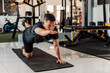 © Mdv Edwards - Southeast Asian man in his 50s balances in bird dog pose on a mat, focusing on core strength and coordination in the gym.