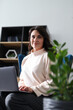 © Andrii Zastrozhnov - Young hispanic female sitting in modern office with laptop and shelving unit