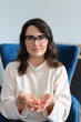 © Andrii Zastrozhnov - Young caucasian female with glasses holding nuts in blue chair