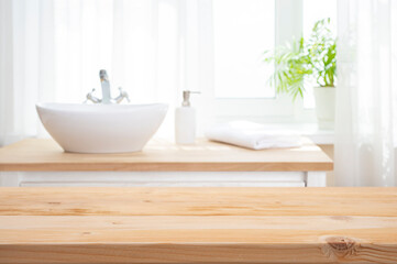 Wall Mural - empty wooden table top as mock up for product montage on blurred bathroom sink interior background