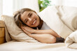 © Maria Vitkovska - Happy young woman waking up in bed smiling and winking