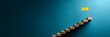 © Graini - Wooden blocks stairs leading to a yellow flag symbolize success achievement progress and growth on teal background