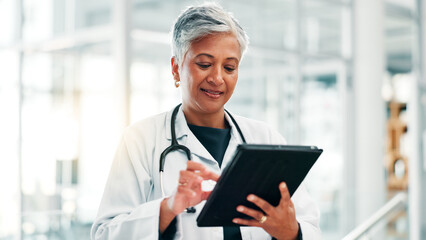 Poster - Mature woman, doctor and research with tablet for medical discovery, news or healthcare service at hospital. Female person, health worker or executive browsing with technology for telehealth or app