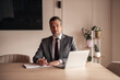 © Jelena - Confident Businessman Working at Desk in Modern Office Environment