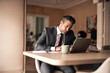 © Jelena - Professional Businessman Working at Desk with Laptop and Coffee