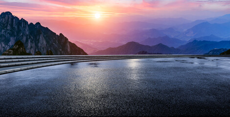 Wall Mural - wet asphalt road and mountain range with beautiful sky clouds at sunset