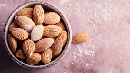 Aufkleber - Close-up of a bowl filled with almonds on a pink surface.