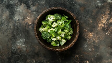 Poster - Overhead shot of a wooden bowl filled with steamed broccoli florets and fresh parsley on a dark textured background.