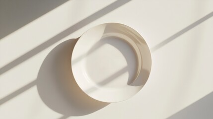 Poster - White plate on white background with sunlight shadows.