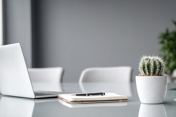 Poster - Workspace with laptop, notebook, pen, and cactus on a modern table in a bright office setting