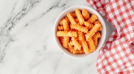Poster - Top view of a bowl of cooked rotini pasta in tomato sauce on a marble surface with a red and white checkered napkin.