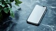© ADI - Blank smartphone screen on dark marble surface with plant
