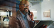 © peopleimages.com - Tablet, cubicle or black man with phone call for talking, asset management or financial advice. African portfolio manager, glass and negotiation in hybrid booth for investment, deal or private equity