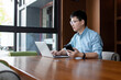 © zhu difeng - asian businessman working on laptop and smart phone in office