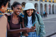 © bernardbodo - Tourists using smart phone and smiling in lisbon, portugal