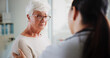© peopleimages.com - Sad woman, doctor and empathy in clinic, healthcare and consultation with support, help and talking. Pensioner, senior patient or medical with professional, results and sympathy with stress or cancer