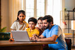 © StockImageFactory - Family scrolling and discussing on laptop while sitting together at home in modern living room