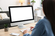 © New Africa - Woman looking at monitor with blank screen at wooden table indoors. Mockup for design