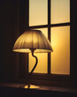 © AcikLens - Lamp on window sill glowing at twilight hour.