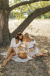 © Buyanskyy Production - Women Sharing Fruit During Picnic In Sunny Forest