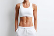 © Oksana_Latysheva - Woman's Midsection in White Sportswear  Isolated On White Background. Woman in Sportswear Showing Abdominal Muscles