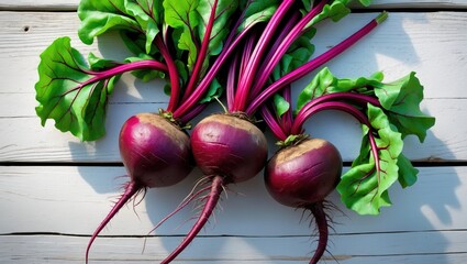 Poster - Young raw beetroot with tops resting on a wooden background.