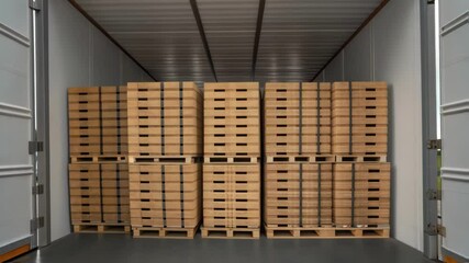 Poster - Cardboard boxes stacked on wooden pallets moving inside truck trailer