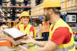 © Dejan - Female warehouse employee passing a box to male coworker during work shift.