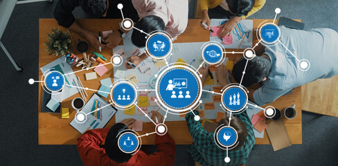 Poster - a top-down view of a collaborative workspace where a diverse group is creatively engaged in planning
