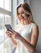 © Meri - smiling woman at the window using her smartphone