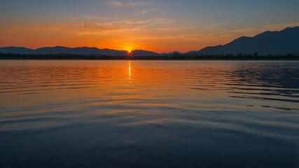 Poster - Stunning Sunset Over Calm Lake With Vibrant Colors Reflecting on the Water, Framed by Mountains at Dusk in a Serene Natural Landscape