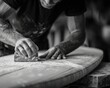 © Constantinos - A craftsman's hands meticulously sand a wooden board, dust swirling around his focused efforts.  Black and white photography highlights the detail.