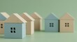 © Manji - House Models in a Row on Green Background Property Concept