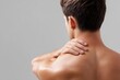 © Irina Ukrainets - A man gently rubbing his shoulder in a relaxed pose. The image captures a moment of self-care and focus on wellness. Ideal for health, fitness, and wellness themes. AI