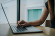 © Dara-Sroi - Woman's hands typing on laptop keyboard. Freelance or self-employed woman sitting at wooden desk with phone and smartphone.