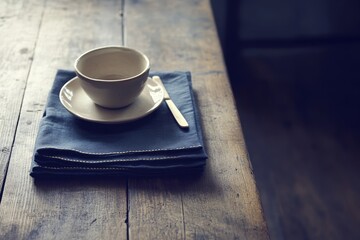 Poster - Empty ceramic cup and saucer on a wooden table.
